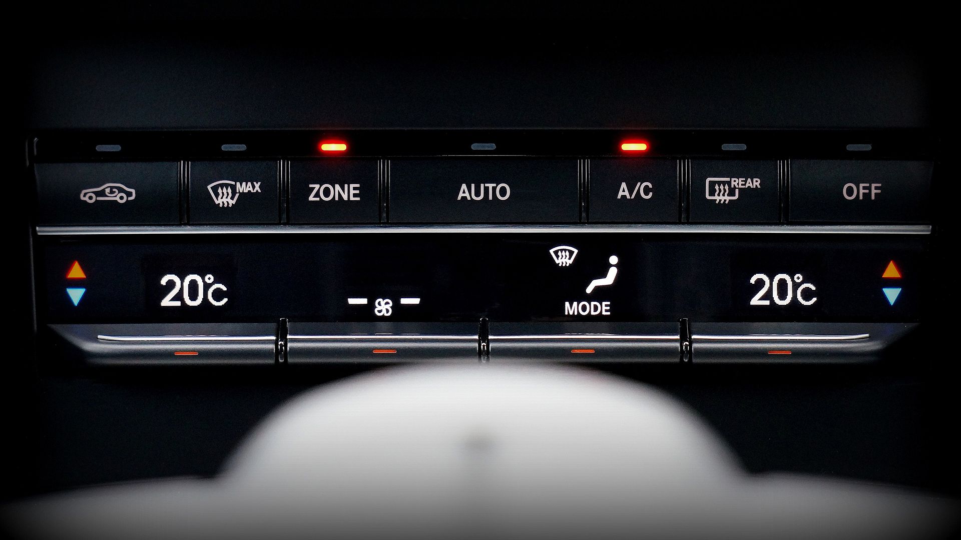 Close-up image of a car's climate control panel with digital temperature display.
